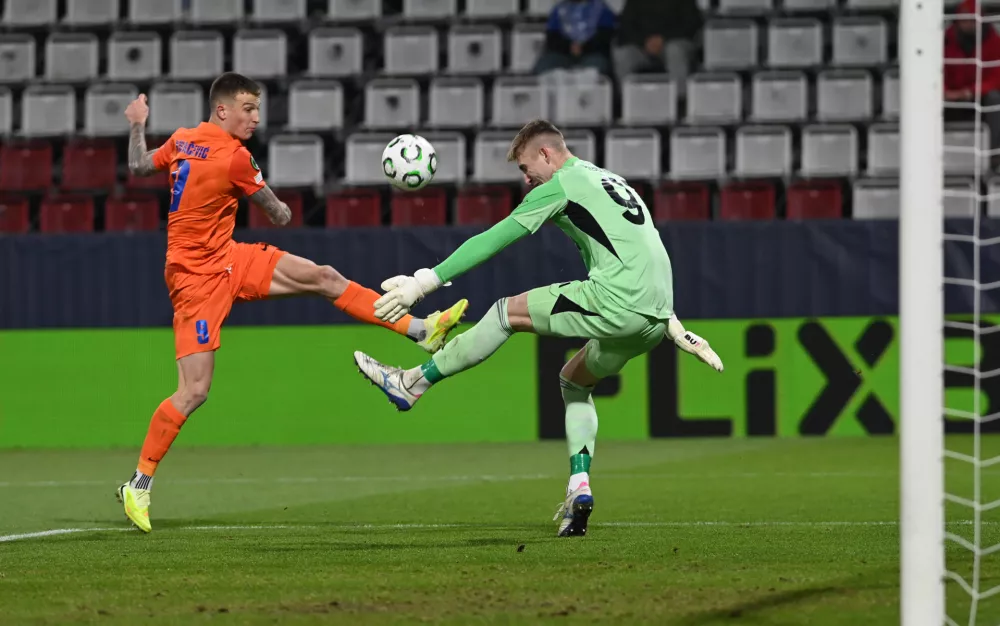 27 November 2025, Czech Republic, Olomouc: Celje's Franko Kovacevic and Olomouc goalkeeper Jan Koutny battle for the ball during the UEFA Europa Conference League soccer match between SK Sigma Olomouc and NK Celje at Andruv stadium. Photo: Peřina Luděk/CTK/dpa