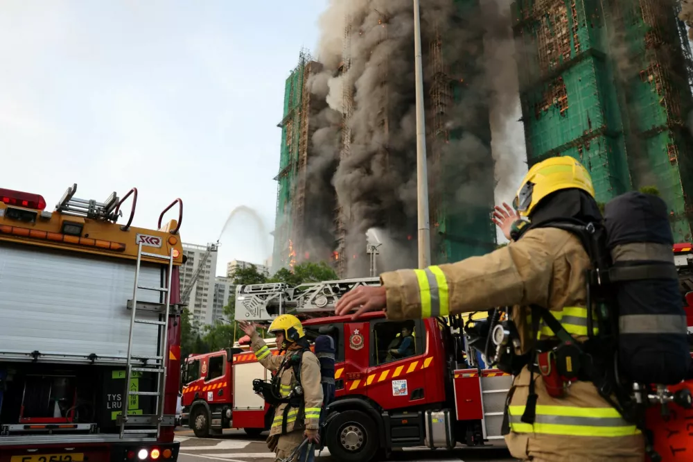 Firefighters work as efforts are underway to extinguish flames engulfing bamboo scaffolding across multiple buildings at the Wang Fuk Court housing estate in Tai Po, Hong Kong, China, November 26, 2025. REUTERS/Tyrone Siu