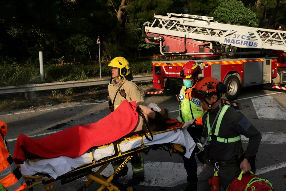 Emergency workers shift a casualty following fire across multiple buildings at Wang Fuk Court housing estate, in Tai Po, Hong Kong, China, November 26, 2025. REUTERS/Tyrone Siu
