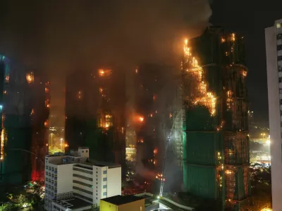 Firefighters work to extinguish flames, as fire burns bamboo scaffolding across multiple buildings at Wang Fuk Court housing estate, in Tai Po, Hong Kong, China, November 26, 2025. REUTERS/Tyrone Siu