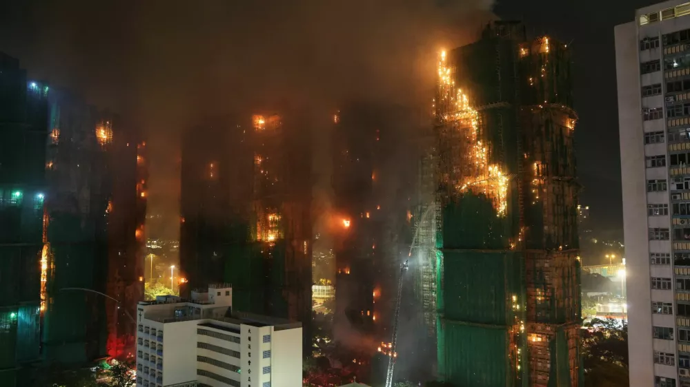 Firefighters work to extinguish flames, as fire burns bamboo scaffolding across multiple buildings at Wang Fuk Court housing estate, in Tai Po, Hong Kong, China, November 26, 2025. REUTERS/Tyrone Siu