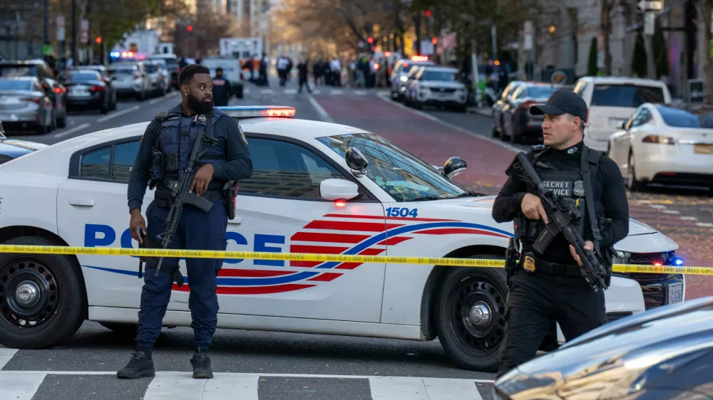 26 November 2025, US, WashingtonA D.C. Police officer and a Secret Service Uniformed Division officer block off a street with their rifles slung after two National Guardsmen were shot near the White House. PhotoJoey Sussman/ZUMA Press Wire/dpa