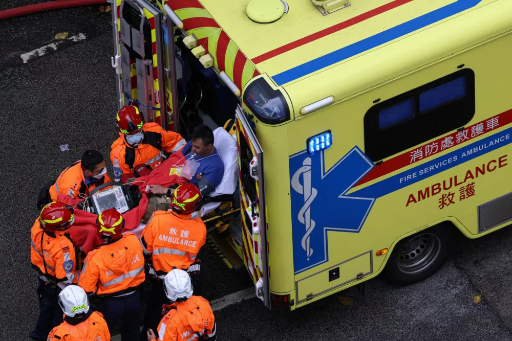 An injured firefighter boards an ambulance after being rescued from the scene of a major fire at Wang Fuk Court housing estate, in Tai Po, Hong Kong, China, November 27, 2025. REUTERS/Tyrone Siu