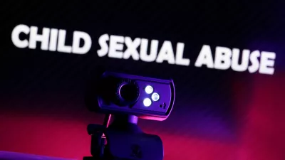 FILE PHOTO: A web camera is seen in front of the displayed words "Child Sexual Abuse" in this illustration taken October 21, 2025. REUTERS/Dado Ruvic/Illustration/File Photo