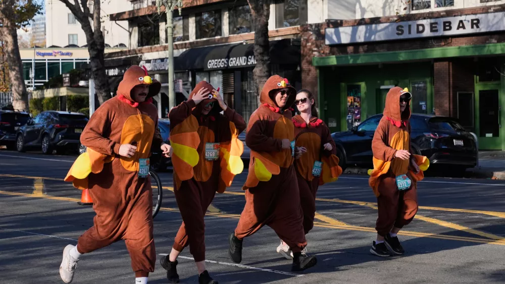 A group of people wearing turkey costumes run during the Oakland Turkey Trot in Oakland, Calif., Thursday, Nov. 27, 2025. (AP Photo/Godofredo A. Vásquez)