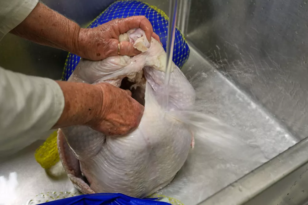 Retired high school cafeteria worker Shirley Mease prepares one of many turkeys she'll cook at Reeds Spring High School to provide 700 free Thanksgiving meals for community members Wednesday, Nov. 26, 2025, in Reeds Spring, Mo. (AP Photo/Jeff Roberson)