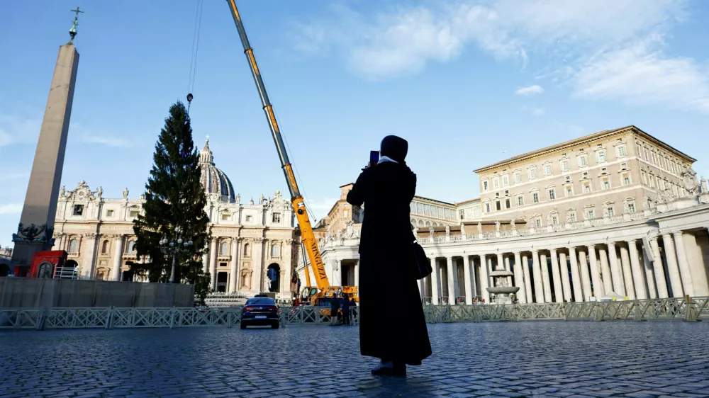 A person takes a photo of the Christmas tree in St. Peter's Square ahead of the festive season at the Vatican, November 27, 2025. REUTERS/Matteo Minnella   TPX IMAGES OF THE DAY