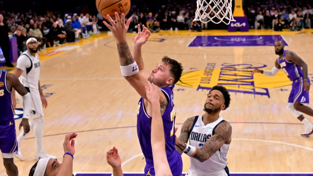 Nov 28, 2025; Los Angeles, California, USA; Los Angeles Lakers guard Luka Doncic (77) reaches for a rebound in the second half against the Dallas Mavericks at Crypto.com Arena. Mandatory Credit: Jayne Kamin-Oncea-Imagn Images