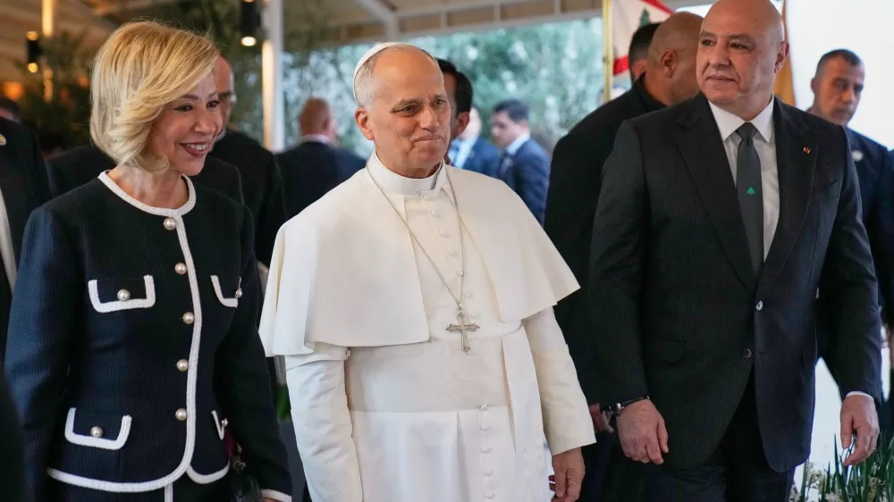 Pope Leo XIV, center, is escorted by Lebanese President Joseph Aoun, right, and First Lady Nehmat Aoun after his arrival at Beirut International Airport in Beirut, Lebanon, Sunday, Nov. 30, 2025.(AP Photo/Hussein Malla)