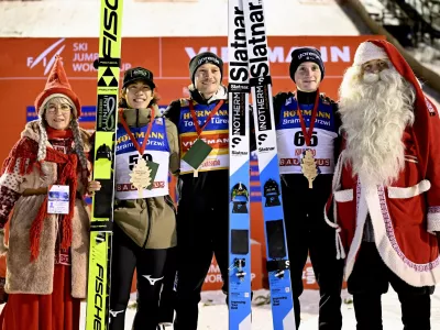 Winner Anze Lanisek of Slovenia, center, 2nd placed Ren Nikaido of Japan, 2nd left, and 3rd placed Domen Prevc of Slovenia celebrate on the podium after men's ski jumping large hill HS142 at the FIS World Cup Ruka Nordic in Kuusamo, Finland, Saturday Nov. 29, 2025. (Roni Rekomaa/Lehtikuva via AP)