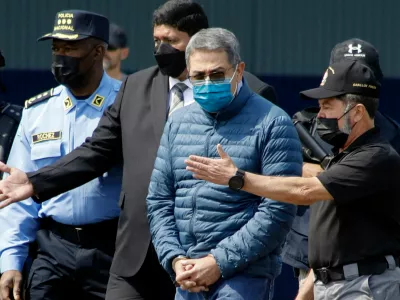 FILE - Former Honduran President Juan Orlando Hernandez, second from right, is taken in handcuffs to a waiting aircraft as he is extradited to the United States, at an Air Force base in Tegucigalpa, Honduras, April 21, 2022. (AP Photo/Elmer Martinez, File)
