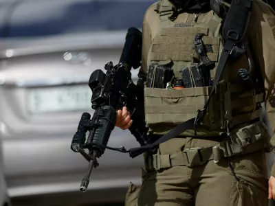 An Israeli soldier holds a gun, while taking part in an operation in Ramallah, in the Israeli-occupied West Bank, December 1, 2025. REUTERS/Mohamad Torokman