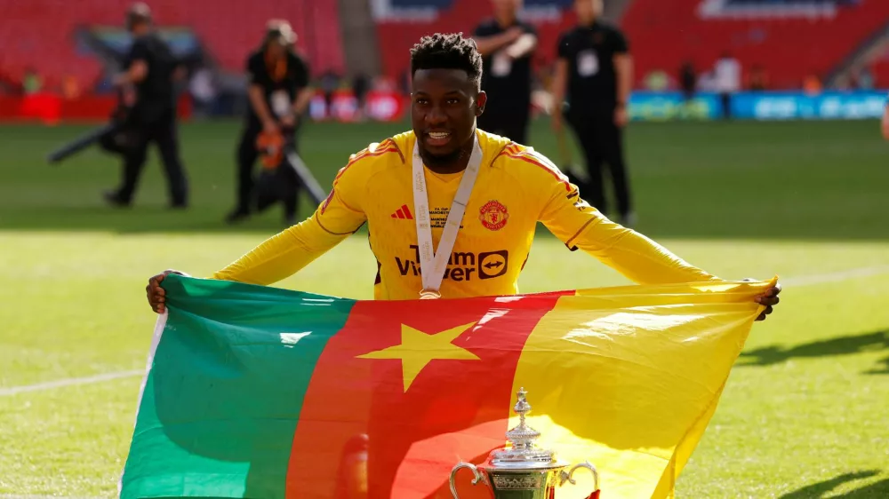 FILE PHOTO: Soccer Football - FA Cup - Final - Manchester City v Manchester United - Wembley Stadium, London, Britain - May 25, 2024 Manchester United's Andre Onana poses with the flag of Cameroon and the trophy as he celebrates after winning the FA Cup Action Images via Reuters/Andrew Couldridge/File Photo