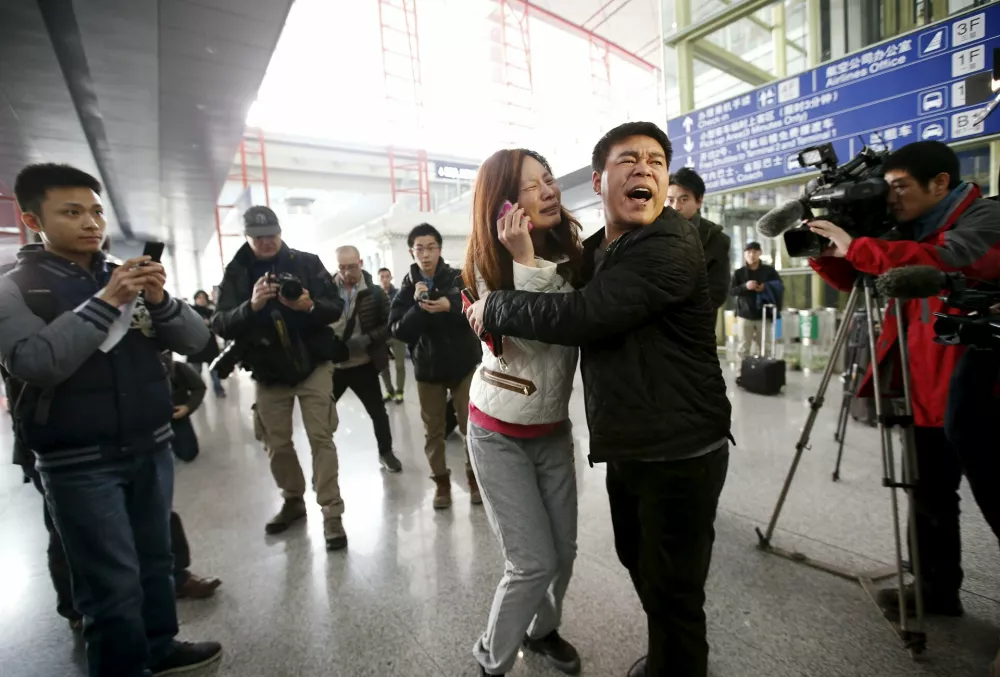 ﻿A relative (woman in white) of a passenger onboard Malaysia Airlines flight MH370 cries as she talks on her mobile phone at the Beijing Capital International Airport in Beijing in this March 8, 2014 file photo. Malaysia is "almost certain" that plane debris found on Reunion Island in the Indian Ocean is from a Boeing 777, the deputy transport minister said on July 30, 2015, heightening the possibility it could be wreckage from missing Flight MH370. REUTERS/Kim Kyung-Hoon/Files