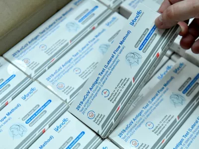 A factory worker at CIGA Healthcare Ltd. picks up a box of COVID-19 antigen lateral flow test before shrink wrapping it for international export, in Ballymena, Northern Ireland June 17, 2022. Picture taken June 17, 2022. Under the Post-Brexit Northern Ireland protocol, continued access to the European Union's single market at the expense of the rest of the United Kingdom is proving beneficial for the region's exporters in tougher economic times. REUTERS/Clodagh Kilcoyne
