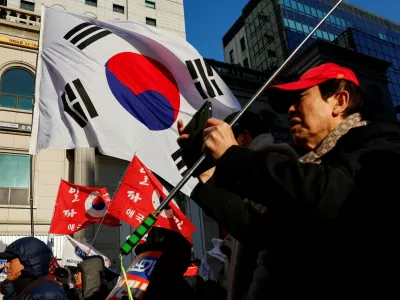 A far-right wing protester uses his phone during a rally to mark the first anniversary of former President Yoon Suk Yeol's December 3, 2024 martial law declaration, which they say was justified, near the headquarters of the People Power Party, in Seoul, South Korea, December 3, 2025. REUTERS/Kim Soo-hyeon