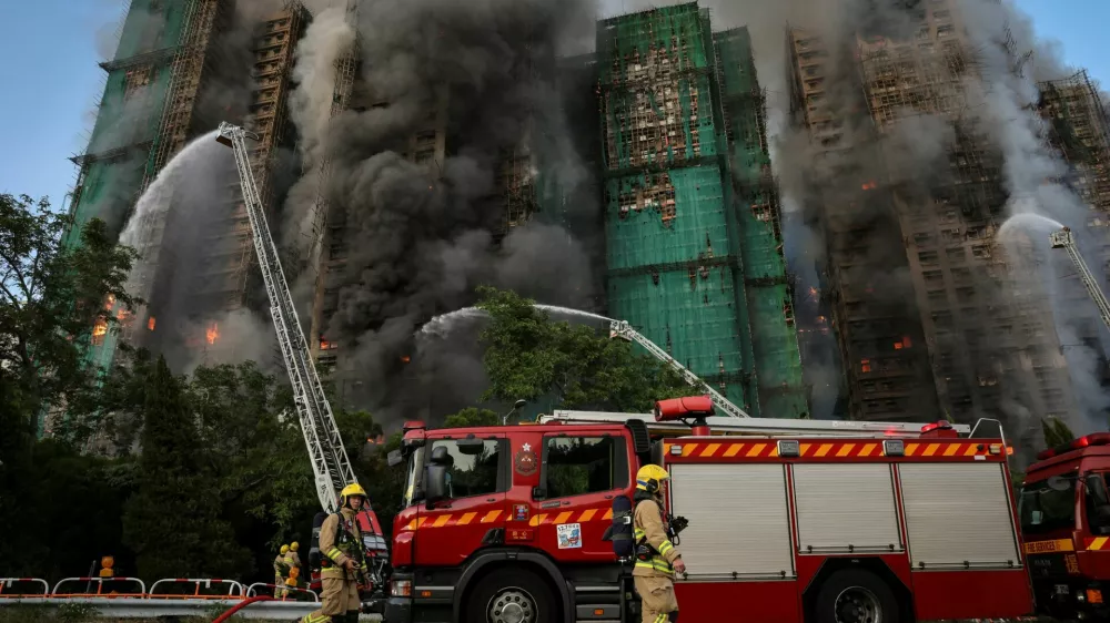 Firefighters walk near the site of a major fire at Wang Fuk Court housing complex, during a deadly fire, in Tai Po, Hong Kong, China, November 26, 2025. REUTERS/Tyrone Siu     SEARCH "HONG KONG FIRE PICTURE" FOR THIS STORY. SEARCH "WIDER IMAGE" FOR ALL STORIES.