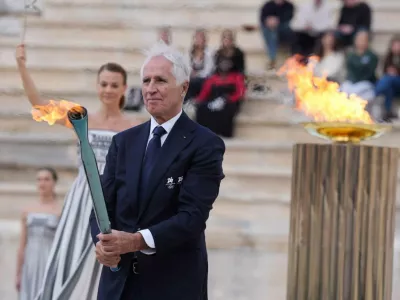 04 December 2025, Greece, AthenGiovanni Malago, President of the Milano Cortina 2026 Organizing Committee, holds the Olympic Flame during the Olympic Flame Handover Ceremony for the Milano Cortina 2026 Winter Games at Panathenaic Stadium PhotoClaudio Furlan/LaPresse via ZUMA Press/dpa