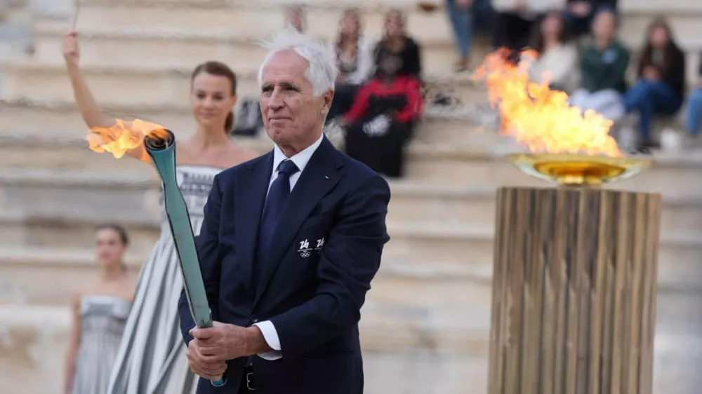04 December 2025, Greece, AthenGiovanni Malago, President of the Milano Cortina 2026 Organizing Committee, holds the Olympic Flame during the Olympic Flame Handover Ceremony for the Milano Cortina 2026 Winter Games at Panathenaic Stadium PhotoClaudio Furlan/LaPresse via ZUMA Press/dpa