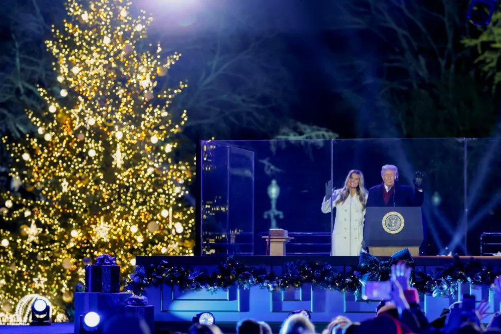 U.S. President Donald Trump and first lady Melania Trump wave on stage during the National Christmas Tree lighting ceremony at the White House in Washington, D.C., U.S., December 4, 2025. REUTERS/Brian Snyder