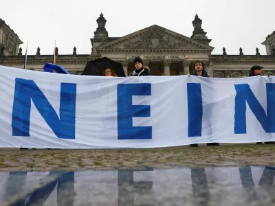 People hold a banner that partially reads "No", in front of the Reichstag building during a protest against compulsory military service in Berlin, Germany December 5, 2025. REUTERS/Christian Mang