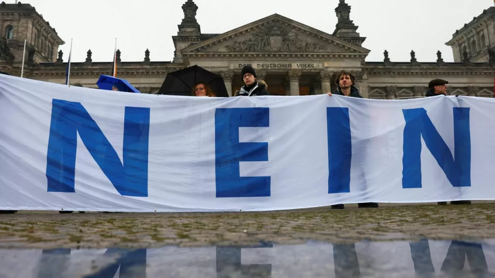 People hold a banner that partially reads "No", in front of the Reichstag building during a protest against compulsory military service in Berlin, Germany December 5, 2025. REUTERS/Christian Mang