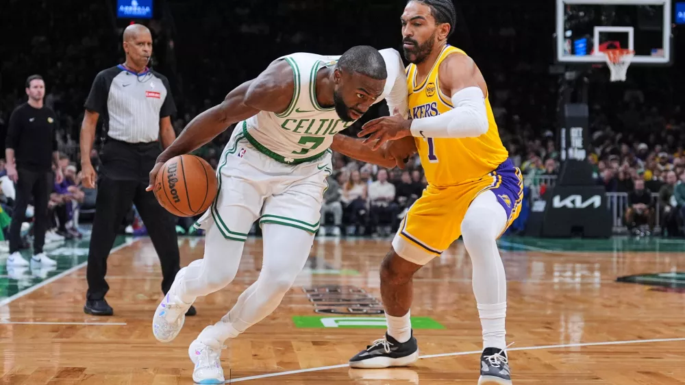Boston Celtics guard Jaylen Brown, left, drives to the basket against Los Angeles Lakers guard Gabe Vincent, right, during the first half of an NBA basketball game, Friday, Dec. 5, 2025, in Boston. (AP Photo/Charles Krupa)