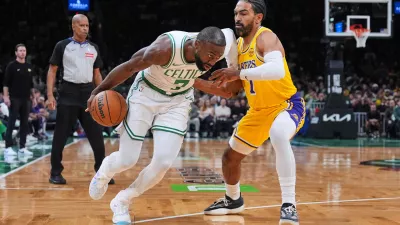 Boston Celtics guard Jaylen Brown, left, drives to the basket against Los Angeles Lakers guard Gabe Vincent, right, during the first half of an NBA basketball game, Friday, Dec. 5, 2025, in Boston. (AP Photo/Charles Krupa)