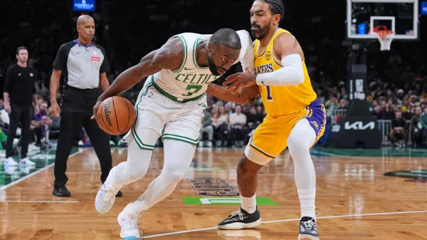 Boston Celtics guard Jaylen Brown, left, drives to the basket against Los Angeles Lakers guard Gabe Vincent, right, during the first half of an NBA basketball game, Friday, Dec. 5, 2025, in Boston. (AP Photo/Charles Krupa)