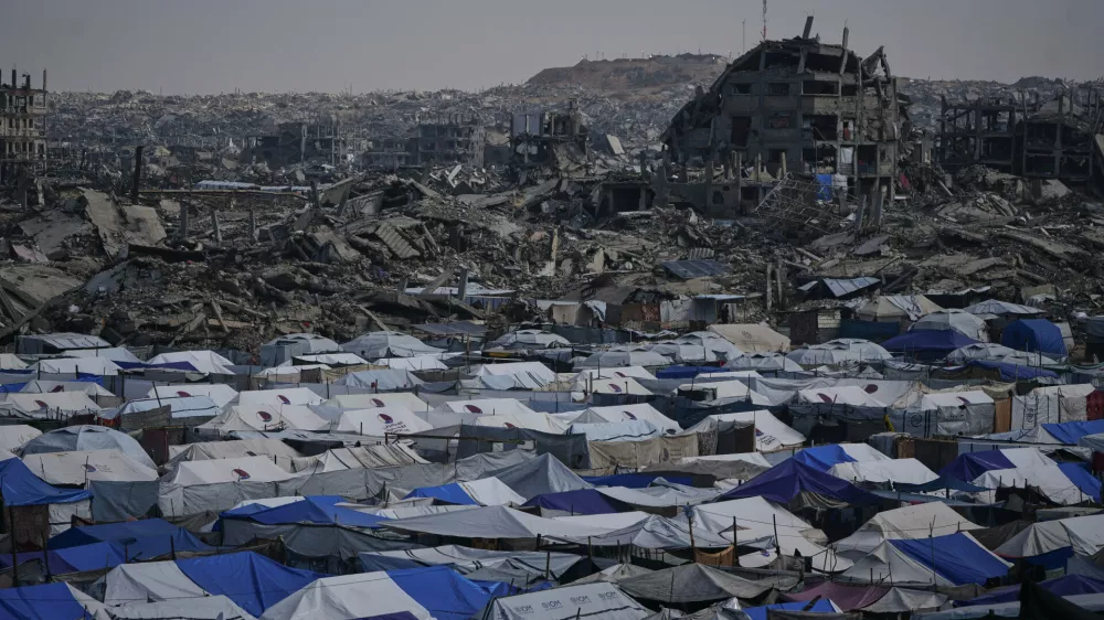 Tents sheltering displaced Palestinians stand amid the destruction left by the Israeli air and ground offensive in Gaza City Friday, Dec. 5, 2025. (AP Photo/Abdel Kareem Hana)