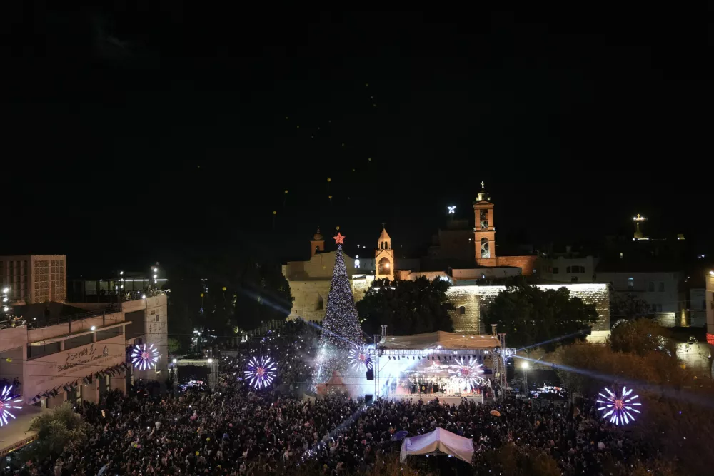 Palestinians take part in a Christmas tree–lighting event in Manger Square, next to the Church of the Nativity, traditionally regarded as the birthplace of Jesus Christ ahead of Christmas in the West Bank city of Bethlehem Saturday, Dec. 6, 2025. (AP Photo/Mahmoud Illean)