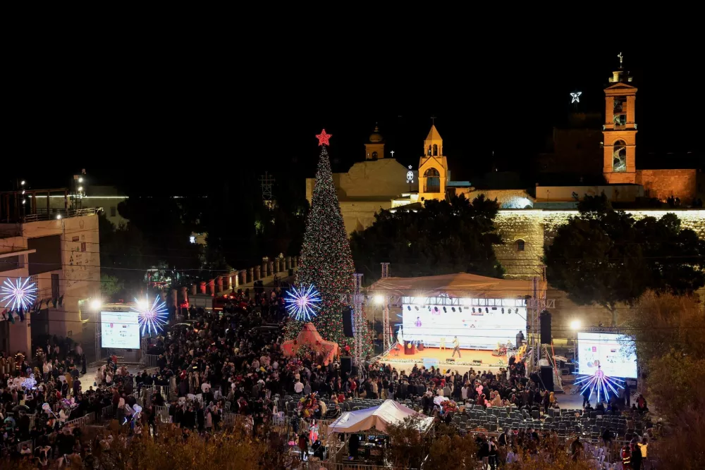 Palestinians light up a Christmas tree in Manger Square outside the Church of the Nativity, in Bethlehem, in the Israeli-occupied West Bank, December 6, 2025. REUTERS/Mussa Qawasma