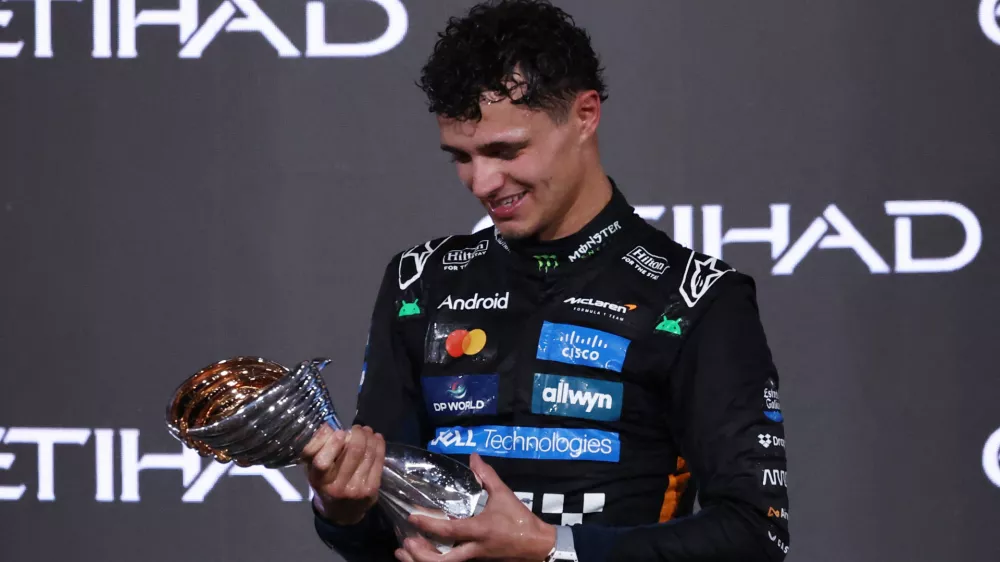 Formula One F1 - Abu Dhabi Grand Prix - Yas Marina Circuit, Abu Dhabi, United Arab Emirates - December 7, 2025 McLaren's Lando Norris celebrates on the podium with the trophy after becoming the 2025 Formula One World Champion REUTERS/Amr Alfiky