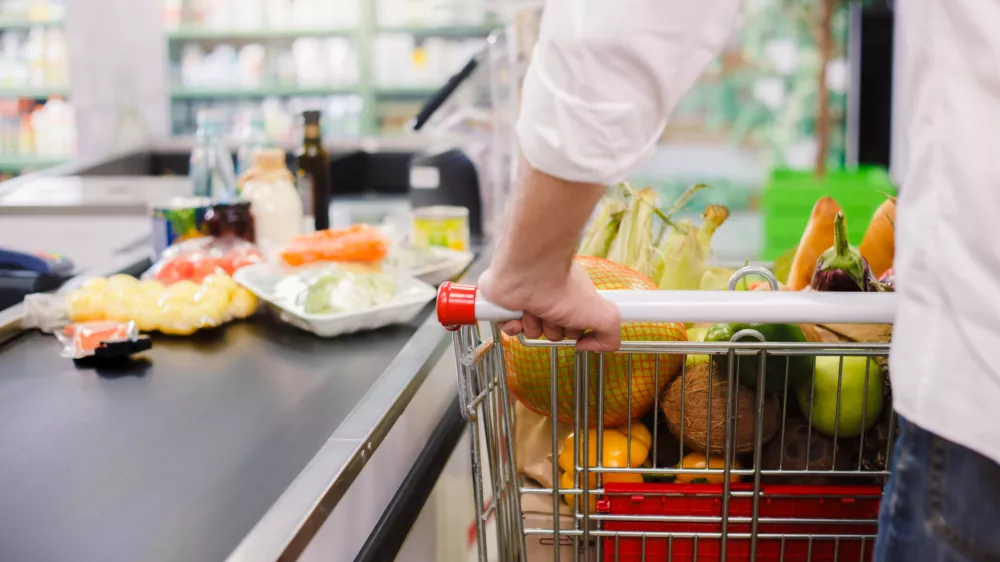 Person buying food products in the supermarket queue / Foto: Sergei Gnatiuk