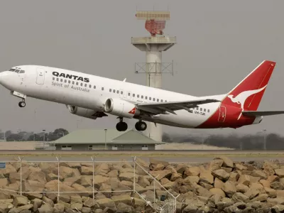 A Qantas passenger jet lifts off in front of a radar tower at Sydney Airport November 22, 2006. Macquarie Bank Ltd. and private equity firm Texas Pacific Group are leading a plan to buy out Qantas Airways Ltd., Australia's biggest airline said on Wednesday sending up its shares 21 per cent. REUTERS/Will Burgess  (AUSTRALIA)