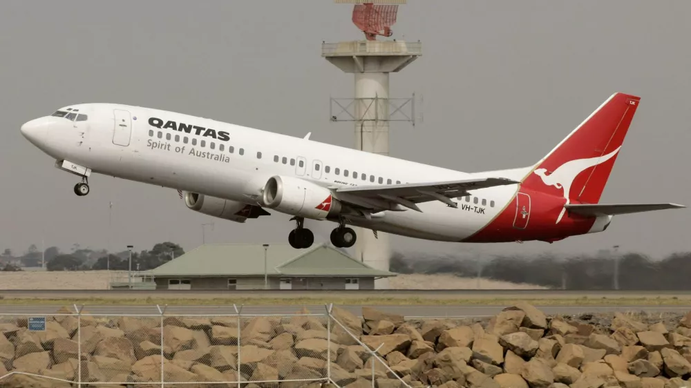A Qantas passenger jet lifts off in front of a radar tower at Sydney Airport November 22, 2006. Macquarie Bank Ltd. and private equity firm Texas Pacific Group are leading a plan to buy out Qantas Airways Ltd., Australia's biggest airline said on Wednesday sending up its shares 21 per cent. REUTERS/Will Burgess  (AUSTRALIA)