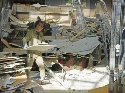 A man clears the debris from a powerful earthquake at a commercial facility in Hachinohe, Aomori prefecture, northern Japan Tuesday, Dec. 9, 2025. (Ren Onuma/Kyodo News via AP)