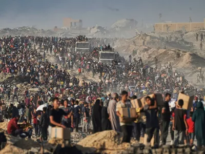 FILE - People carry sacks and boxes of food and humanitarian aid that was unloaded from a World Food Program convoy that had been heading to Gaza City in the northern Gaza Strip, June 16, 2025. (AP Photo/Jehad Alshrafi, File)