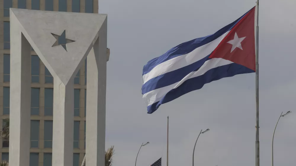 Cuban and American flags fly in the wind outside the American embassy in Havana, Cuba, Tuesday, Jan.14, 2025. (AP Photo/Ariel Ley)