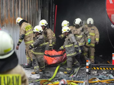 Rescuers carry out the body of a victim from the site of a fire in Jakarta, Indonesia, Tuesday, Dec. 9, 2025. (AP Photo/Dita Alangkara)