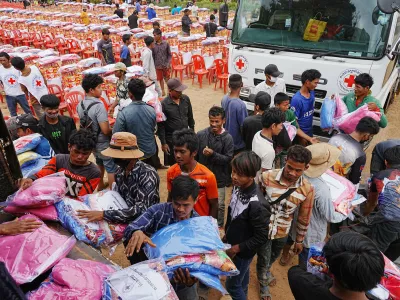 Yong evacuees help other evacuees to carry donation at Batthkoa Buddhist pagoda in Oddar Meanchey province, Cambodia Wednesday, Dec. 10, 2025, after fleeing from home following a fighting between Thailand and Cambodia over territorial claims (AP Photo/Heng Sinith)