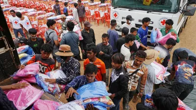 Yong evacuees help other evacuees to carry donation at Batthkoa Buddhist pagoda in Oddar Meanchey province, Cambodia Wednesday, Dec. 10, 2025, after fleeing from home following a fighting between Thailand and Cambodia over territorial claims (AP Photo/Heng Sinith)