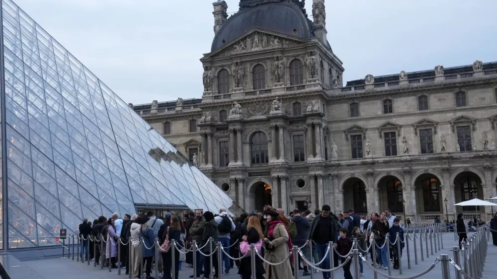 Visitors queue to enter the Louvre museum three days after historic jewels were stolen in a daring daylight heist, Wednesday, Oct. 22, 2025 in Paris. (AP Photo/Thibault Camus)