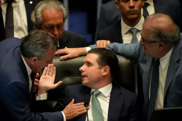 President of the Chamber of Deputies Hugo Motta, center, speaks with congressmen at a session to consider a bill to alter sentencing guidelines for certain crimes including leading a coup d'&eacute;tat, for which former President Jair Bolsonaro was sentenced, in Brasilia, Brazil, Tuesday, Dec. 9, 2025. (AP Photo/Eraldo Peres)