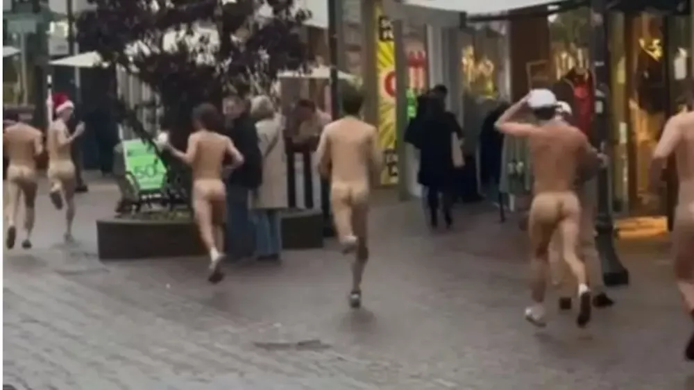 Tek po središču mesta. Mnogim so med prizorom z glave padle božične kape, ki so jih pustili za sebo. / Foto: Zajem Zaslona