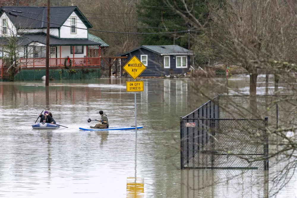 11 December 2025, US, Sultana: People paddle through flood waters from the Skykomish River inundating a portion of downtown Sultana, after a trio of atmospheric rivers drenched the region. Forecasts said that many rivers in the Pacific Northwest would reach catastrophic flood levels and the governor has declared a state of emergency. Photo: M. Scott Brauer/ZUMA Press Wire/dpa