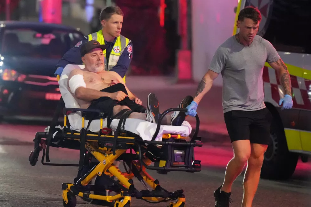 Emergency workers transport a person on a stretcher after a reported shooting at Bondi Beach in Sydney, Sunday, Dec. 14, 2025. (AP Photo/Mark Baker)