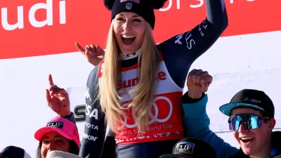 Alpine Skiing - FIS Alpine Ski World Cup - Women's Downhill - St. Moritz, Switzerland - December 13, 2025 Lindsey Vonn of the U.S. celebrates on the podium with her team after finishing second place in the Women's Downhill REUTERS/Denis Balibouse
