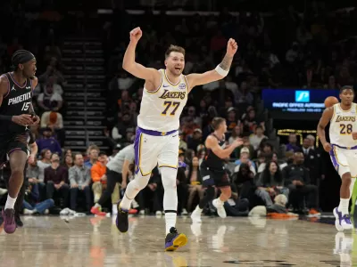 Los Angeles Lakers guard Luka Doncic (77) reacts after scoring against the Phoenix Suns during the second half of an NBA basketball game, Sunday, Dec. 14, 2025, in Phoenix. (AP Photo/Rick Scuteri)