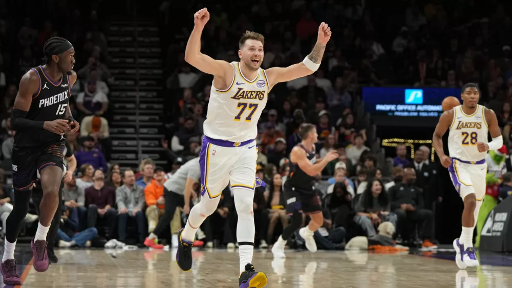 Los Angeles Lakers guard Luka Doncic (77) reacts after scoring against the Phoenix Suns during the second half of an NBA basketball game, Sunday, Dec. 14, 2025, in Phoenix. (AP Photo/Rick Scuteri)
